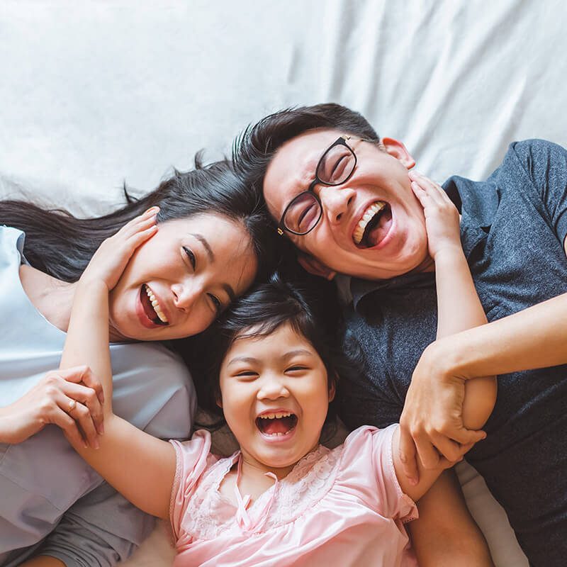 A happy family lying on their bed